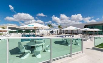 a large outdoor pool surrounded by lounge chairs and umbrellas , providing a relaxing atmosphere for guests at Bristol Aline