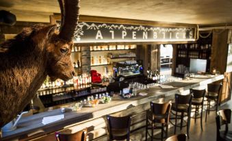 a large brown goat statue stands in the middle of a bar with stools and bottles on the counter at Alpenblick Weggis - Panorama & Alpen Chic Hotel