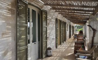 a long , covered walkway with rows of white doors and windows , creating a welcoming atmosphere at Borgo Sentinella
