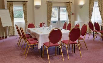 a large conference room with multiple chairs arranged in a square formation around a long table at The Cedars Hotel