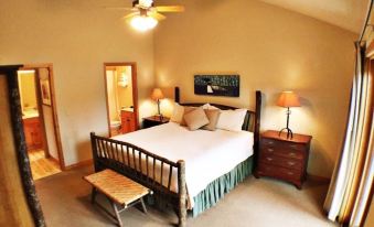 a large bed with a wooden headboard and footboard is in the center of a room with two lamps on either side at Mountain Lake Lodge