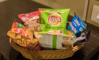 a basket filled with various snacks , including lays chips and king nuts , is placed on a table at Mayas