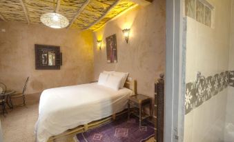 a cozy bedroom with a white bed and a purple rug on the floor , creating a warm and inviting atmosphere at Guest House Bagdad Café