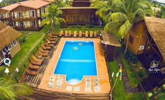 a large swimming pool surrounded by lounge chairs and palm trees in a tropical setting at Aqua Safari Resort