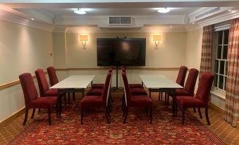 a conference room with a long table , chairs , and a television mounted on the wall at The Woburn