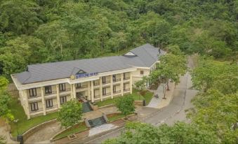 aerial view of a large building surrounded by trees , located on a hillside overlooking the city at Saigon-Ba Be Resort