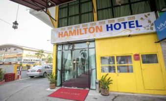 "a building with a yellow sign that says "" hamilton hotel "" and a red carpet outside" at Hamilton Hotel Kajang