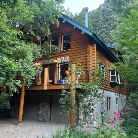 Cozy log cabin secluded in a mountain forest with hot tub, sauna, private patio.