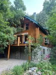 Cozy log cabin secluded in a mountain forest with hot tub, sauna, private patio.