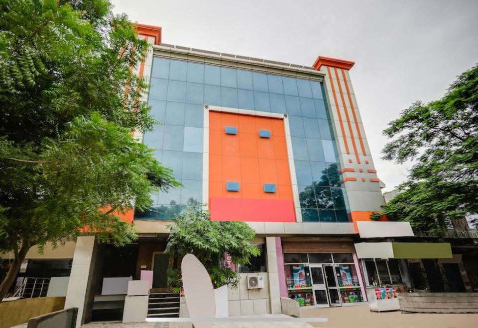 "a modern building with a red and orange facade , surrounded by trees and a sign reading "" centro "" in front of it" at Pinky Hotel