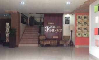 a hotel lobby with a staircase leading to the second floor , where guests can sit and relax at Hotel Mexico