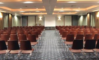 a large conference room with rows of chairs arranged in a semicircle , ready for a meeting at The Savoy Hotel