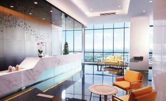 a modern office lobby with a large window and a marble reception desk in the center at Hilton Garden Inn Puchong