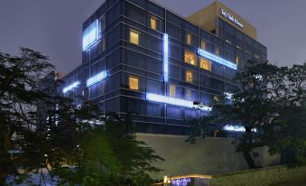 a large building with many windows and blue lights on the side is lit up at night at Taj Club House