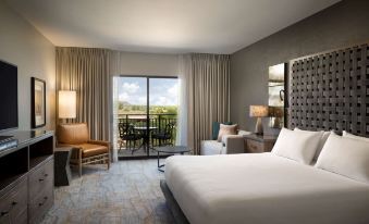 a hotel room with a large bed , a couch , a chair , and a window overlooking the city at Hyatt Regency Tamaya Resort and Spa