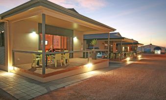 a row of small , two - story houses with a patio area and outdoor furniture on the ground floor at Streaky Bay Hotel Motel