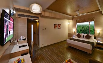 a modern hotel room with wooden floors , white walls , and various furniture pieces including beds , desks , and a table at Sarovar Portico Sasangir