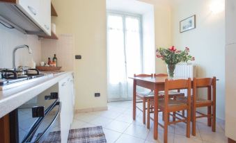 a kitchen with a dining table and chairs , along with a vase of flowers on the table at Hotel La Cretonne