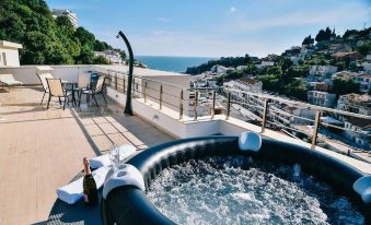 a rooftop hot tub with a bottle of wine and two glasses on a table at Riva