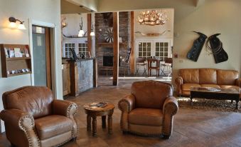 a cozy living room with two leather chairs and a dining table , creating a warm and inviting atmosphere at Lone Star Lodge and Marina