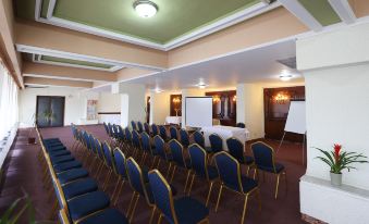 a conference room with rows of chairs arranged in a semicircle , and a whiteboard on the wall at Hotel Belvedere