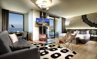 a modern living room with a black and white patterned rug , a gray couch , and a television mounted on the wall at Hard Rock Hotel Tenerife