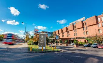 "a large hotel building with a sign that reads "" bayshore hotel "" is shown on a city street" at Sheraton Skyline Hotel London Heathrow