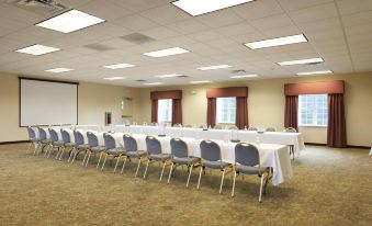 a large , empty conference room with multiple rows of chairs arranged in a semicircle around a table at Country Inn & Suites by Radisson, Manchester Airport, NH