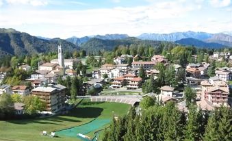 a picturesque village nestled in the mountains , surrounded by lush greenery and a river flowing through the town at Harmony Suite Hotel