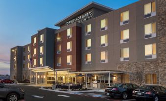 "a modern hotel building with the name "" homeplace suites by marriott "" on it , surrounded by cars and people" at TownePlace Suites Memphis Southaven