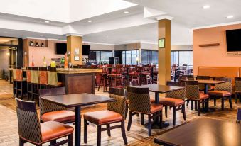 a large dining area with multiple tables and chairs , as well as a bar in the background at Comfort Inn Largo-Washington DC East