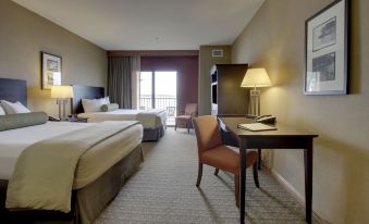 a hotel room with two beds , a desk , and a chair , all neatly arranged in the room at King's Pointe Waterpark Resort