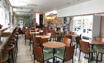 a restaurant with several tables and chairs , a refrigerated display case , and a glass cabinet at Toyoko Inn Aizuwakamatsu Ekimae