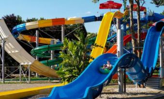 a colorful water park with various slides and play structures for children to enjoy , including a blue slide at Hotel Arborétum