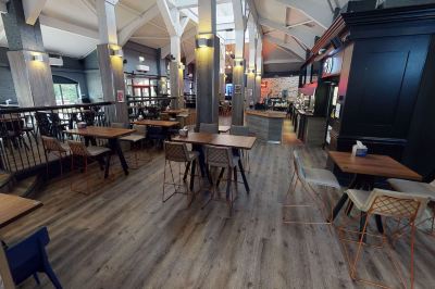 a large restaurant with multiple dining tables and chairs , some of which are occupied by people at Village Hotel Liverpool