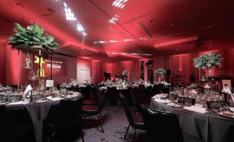 a well - decorated banquet hall with multiple tables set up for a formal event , including wine glasses and centerpieces at voco MANCHESTER - CITY CENTRE