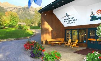 the entrance to a fairmount hot springs resort , with a sign above the building and some flowers in front at Fairmont Hot Springs Resort