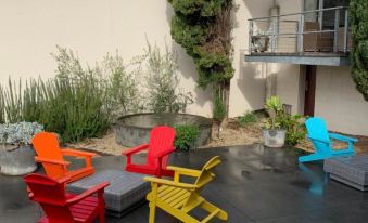 a colorful patio area with several colorful chairs and a green plant in the background at Phoenix Apartments