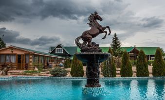 a statue of a horse is standing in the middle of a pool , surrounded by buildings at Allur