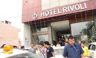 a group of people are standing outside a hotel building , waiting to enter the hotel at Hotel Rivoli