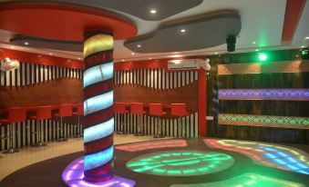 a colorful bar with a spiral design in the center , surrounded by various chairs and tables at Leisure Resort