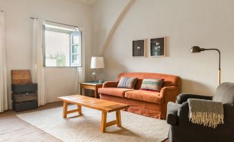 a cozy living room with a brown leather couch , wooden coffee table , and a rug on the floor at São Lourenço do Barrocal