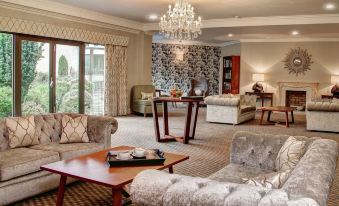 a spacious living room with various furniture , including a couch , chairs , and a dining table at Best Western Plus Centurion Hotel