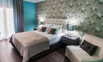 a well - decorated bedroom with a large bed , two chairs , and a lamp on the nightstand at Theasis Hotel Paramythia