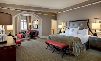 a luxurious hotel room with a king - sized bed , a couch , and a dining table in the room at The Algonquin Resort St. Andrews by-The-Sea, Autograph Collection