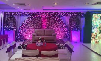 a room set up for a wedding reception , with a couch and chairs arranged in front of a stage at The Grand Hotel