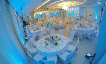 a large , white banquet hall with numerous round tables and chairs set up for a formal event at Hotel Delta