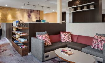 a living room with a couch , coffee table , and bookshelf , creating a cozy and inviting atmosphere at Courtyard Philadelphia Valley Forge/King of Prussia
