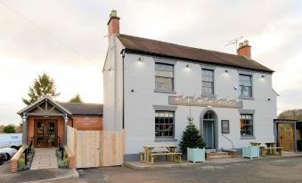 "a white brick building with a sign that reads "" the mariners inn "" and a wooden fence in front" at The Saracens Head