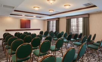 a large conference room with rows of green chairs arranged in a semicircle , and a projector screen mounted on the wall at Homewood Suites by Hilton Wallingford-Meriden